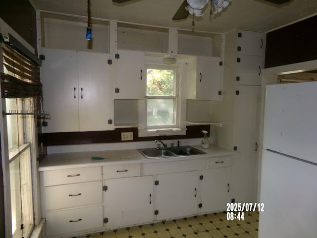 211 W Madison St, Yates Center, KS 66783 - kitchen with freestanding refrigerator, ceiling fan, light countertops, and white cabinetry