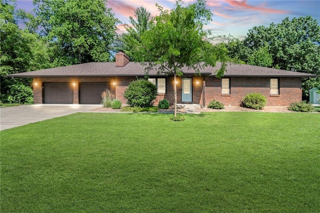 1306 Ruby St, Carrollton, MO 64633 - ranch-style house featuring a garage, concrete driveway, a yard, and brick siding