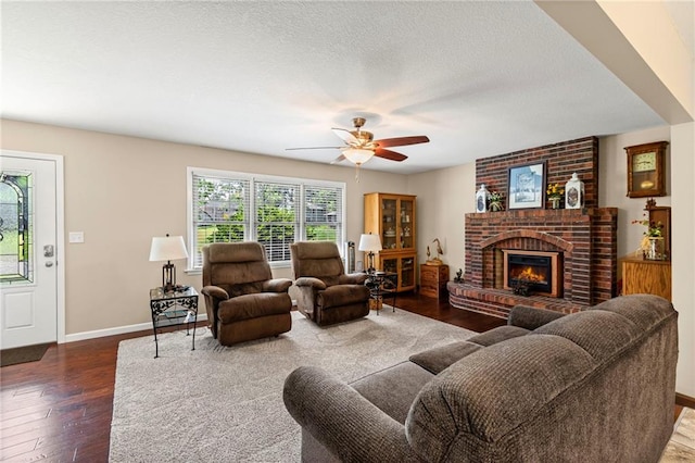 1306 Ruby St, Carrollton, MO 64633 - living room featuring hardwood / wood-style floors, ceiling fan, a fireplace, and a textured ceiling
