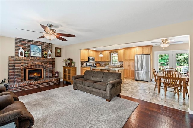 1306 Ruby St, Carrollton, MO 64633 - living area featuring ceiling fan, a fireplace, and wood finished floors
