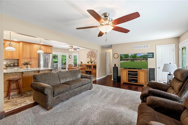 1306 Ruby St, Carrollton, MO 64633 - living area featuring ceiling fan, french doors, and dark wood-style flooring
