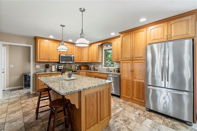 1306 Ruby St, Carrollton, MO 64633 - kitchen featuring appliances with stainless steel finishes, recessed lighting, backsplash, light stone countertops, and a center island
