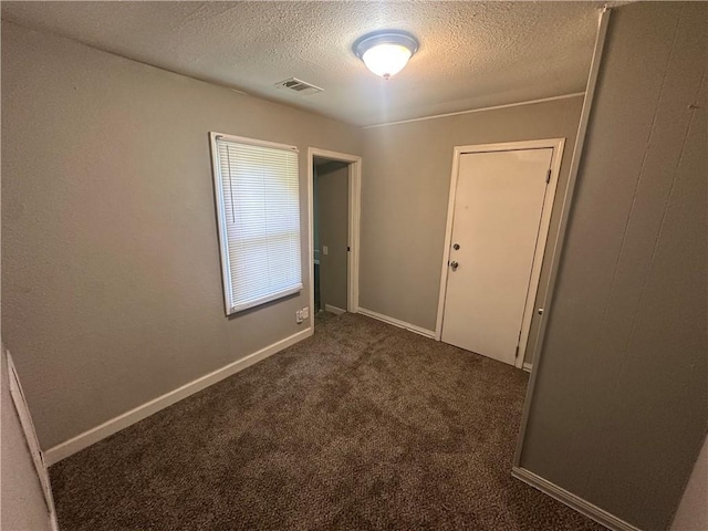 6146 Parkview Ave, Kansas City, KS 66104 - empty room featuring a textured ceiling and dark colored carpet
