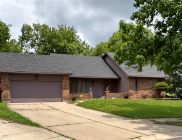 7908 E 96th St, Kansas City, MO 64134 - ranch-style house featuring brick siding, a garage, a front yard, and concrete driveway