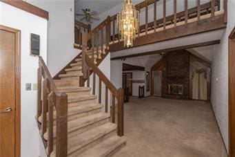 7908 E 96th St, Kansas City, MO 64134 - staircase with a chandelier, a ceiling fan, and carpet flooring