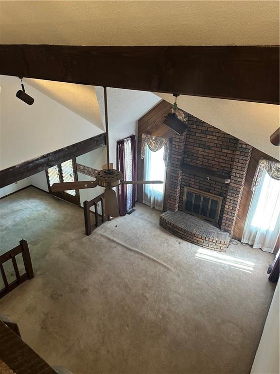 7908 E 96th St, Kansas City, MO 64134 - unfurnished living room with carpet and a brick fireplace