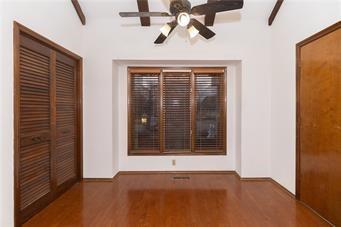 7908 E 96th St, Kansas City, MO 64134 - unfurnished bedroom featuring wood finished floors, a closet, and a ceiling fan