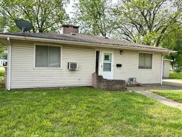2302 Crawford Ave, Parsons, KS 67357 - back of house with a lawn and a chimney
