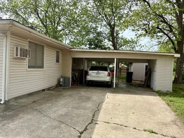 2302 Crawford Ave, Parsons, KS 67357 - view of car parking featuring concrete driveway, a carport, and a wall mounted air conditioner