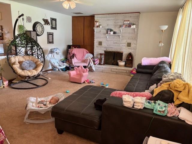 2302 Crawford Ave, Parsons, KS 67357 - carpeted living area with ceiling fan and a fireplace