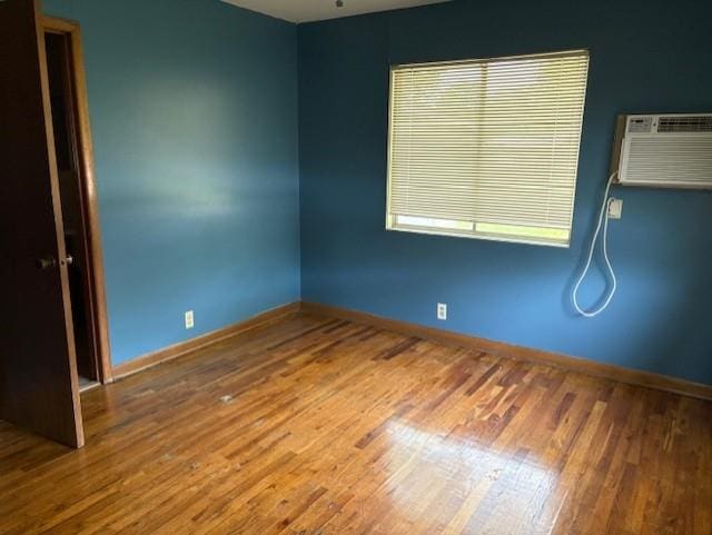 2302 Crawford Ave, Parsons, KS 67357 - empty room with wood finished floors and a wall mounted AC