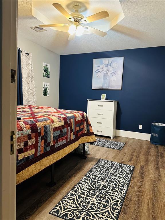 507 E Jefferson St, Pittsburg, KS 66762 - bedroom featuring a textured ceiling, wood finished floors, and a ceiling fan