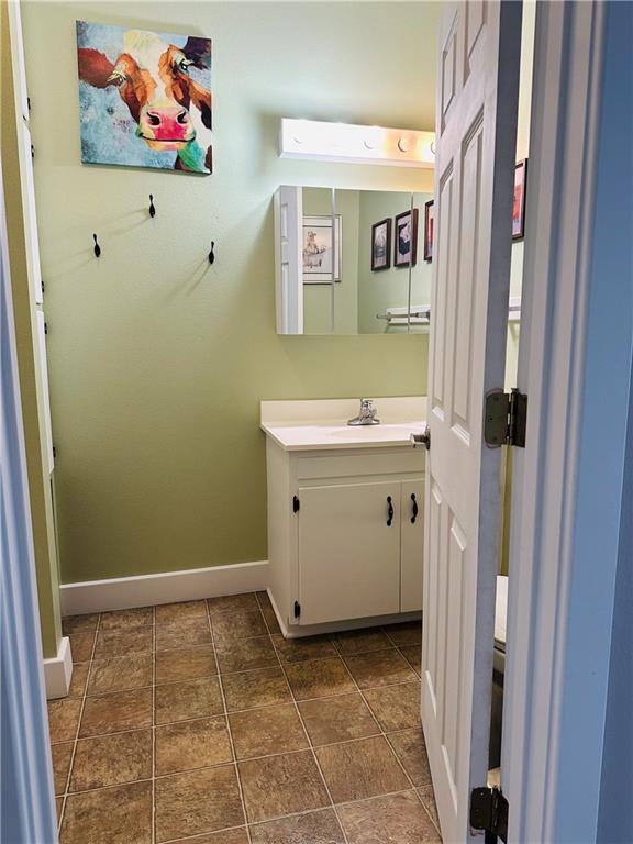 507 E Jefferson St, Pittsburg, KS 66762 - bathroom featuring baseboards and vanity