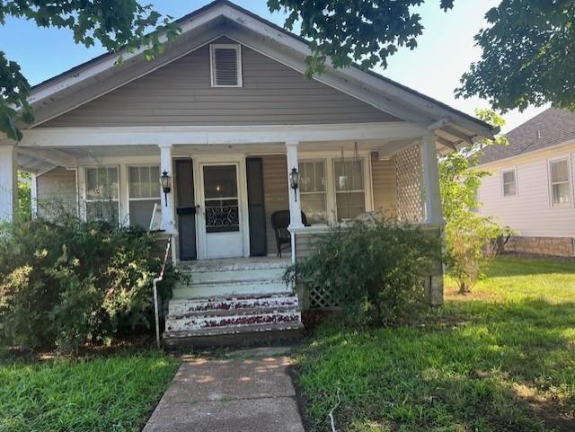 1110 W Main St, Chanute, KS 66720 - bungalow-style house featuring covered porch and a front yard