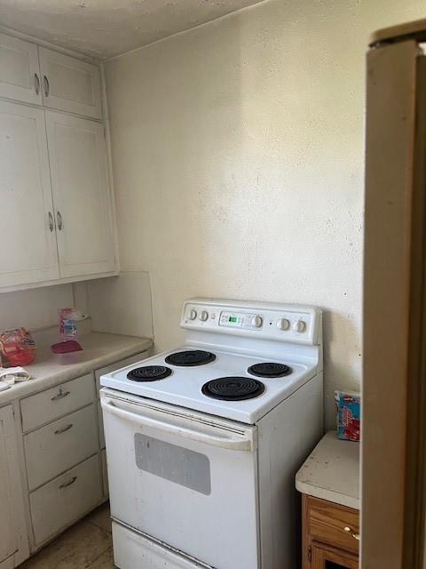 1110 W Main St, Chanute, KS 66720 - kitchen with white range with electric cooktop, light countertops, and white cabinetry