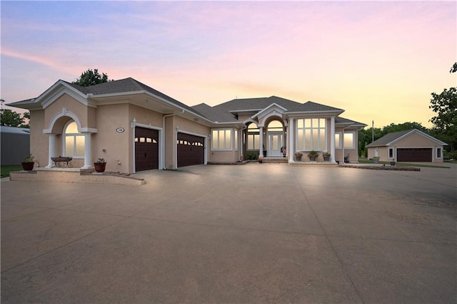 1702 Cedar Ridge Rd, Parsons, KS 67357 - view of front of home with an attached garage, stucco siding, and concrete driveway