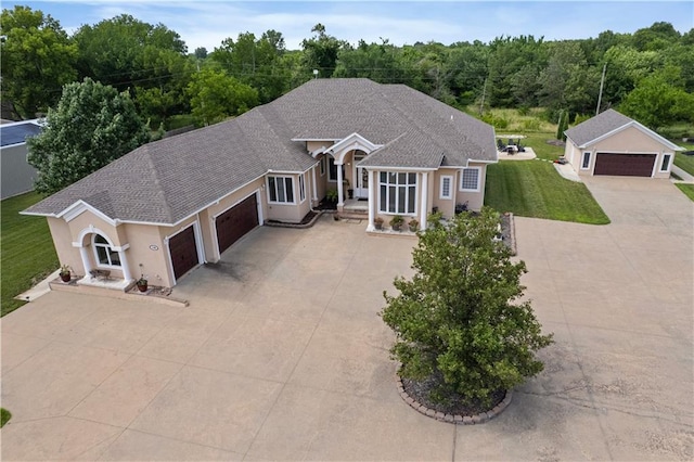 1702 Cedar Ridge Rd, Parsons, KS 67357 - ranch-style house with concrete driveway, a garage, stucco siding, a front lawn, and a shingled roof