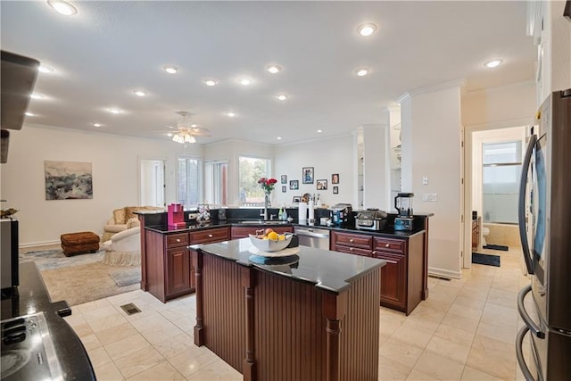 1702 Cedar Ridge Rd, Parsons, KS 67357 - kitchen featuring stainless steel appliances, a kitchen island, dark countertops, open floor plan, and reddish brown cabinets