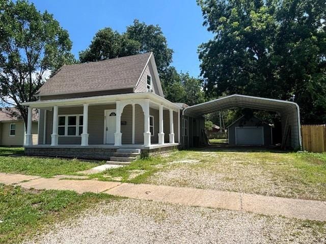 621 N 3rd St, Burlington, KS 66839 - farmhouse inspired home with driveway, a porch, a shingled roof, a carport, and an outdoor structure