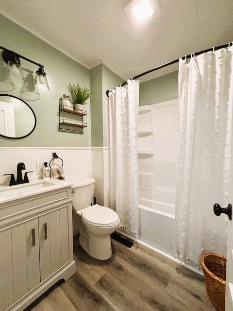 143 N 3rd St, New Strawn, KS 66839 - full bath featuring wood finished floors, vanity, wainscoting, shower / bath combination with curtain, and crown molding