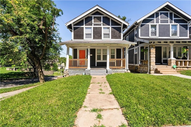 4001 Tracy Ave, Kansas City, MO 64110 - view of front of property with a porch, a front lawn, stone siding, and stucco siding