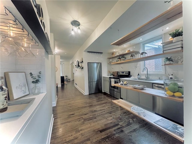1643 Jefferson St, Kansas City, MO 64108 - kitchen featuring appliances with stainless steel finishes, open shelves, backsplash, dark wood finished floors, and light countertops