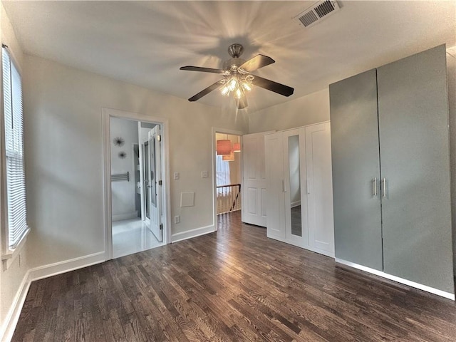1643 Jefferson St, Kansas City, MO 64108 - unfurnished bedroom featuring dark wood-type flooring, connected bathroom, a ceiling fan, and a closet
