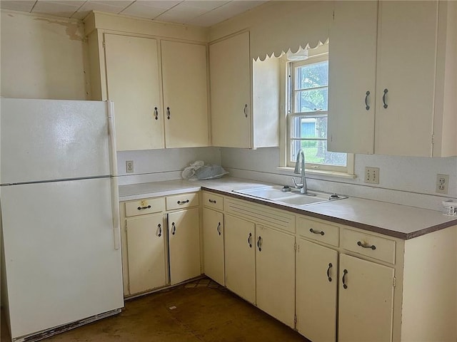 3107 Wood Ave, Parsons, KS 67357 - kitchen with freestanding refrigerator, light countertops, and cream cabinets