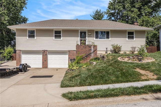 2005 Manor Pl, Blue Springs, MO 64015 - view of front of property with concrete driveway, an attached garage, a front lawn, and brick siding