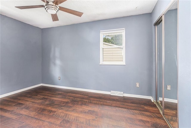 2005 Manor Pl, Blue Springs, MO 64015 - unfurnished bedroom featuring dark wood-style flooring, a closet, and a ceiling fan