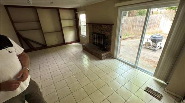 11965 W 66th St, Shawnee, KS 66216 - unfurnished living room with light tile patterned floors and a glass covered fireplace