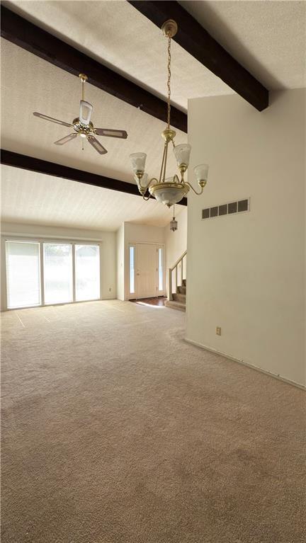 11965 W 66th St, Shawnee, KS 66216 - unfurnished living room with carpet floors, stairs, ceiling fan, a chandelier, and a textured ceiling