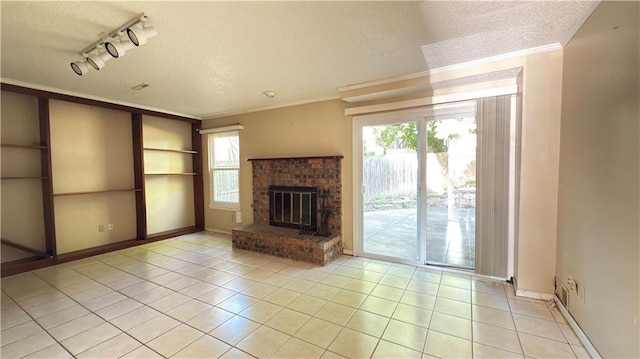 11965 W 66th St, Shawnee, KS 66216 - unfurnished living room with a textured ceiling, light tile patterned floors, track lighting, a brick fireplace, and crown molding