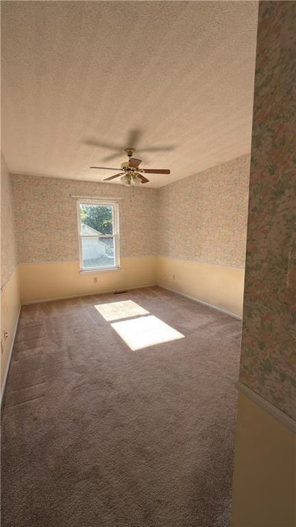 11965 W 66th St, Shawnee, KS 66216 - spare room featuring wallpapered walls, a textured ceiling, a ceiling fan, and carpet flooring