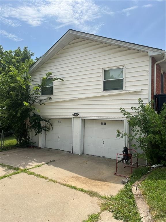 1835-1837 N 77th St, Kansas City, KS 66112 - view of side of home featuring an attached garage and a central AC unit