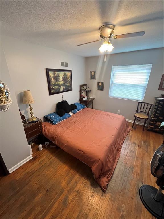 1835-1837 N 77th St, Kansas City, KS 66112 - bedroom featuring hardwood / wood-style floors, a textured ceiling, and ceiling fan