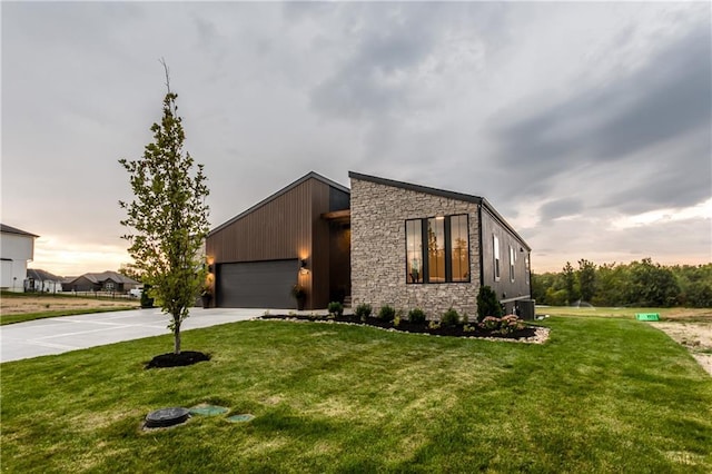 18221 W 168th Ter, Olathe, KS 66062 - contemporary house with driveway, stone siding, an attached garage, and a lawn