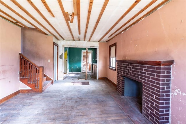 615 Mill St, Neodesha, KS 66757 - unfurnished living room with a brick fireplace, stairs, and wood finished floors