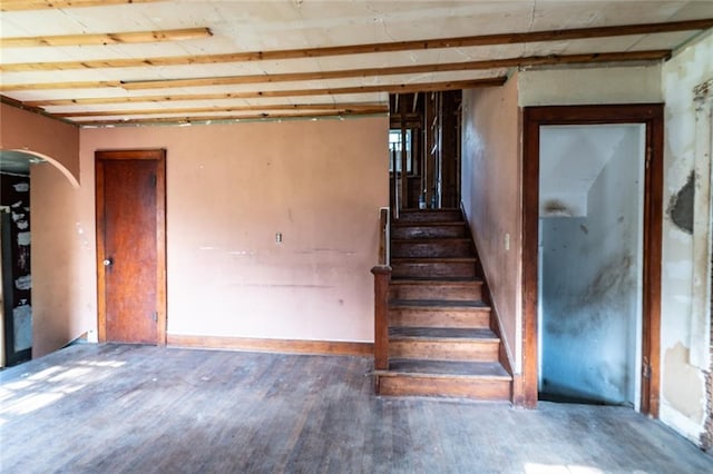 615 Mill St, Neodesha, KS 66757 - staircase featuring wood finished floors and arched walkways