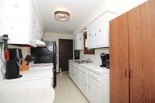 414 N Ash St, Garnett, KS 66032 - kitchen with light countertops, light floors, freestanding refrigerator, white cabinets, and under cabinet range hood