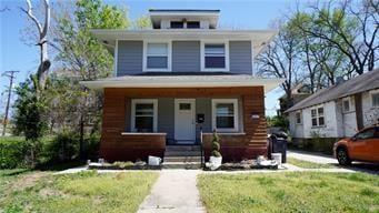 5007 Euclid Ave, Kansas City, MO 64130 - american foursquare style home with a porch and a front lawn