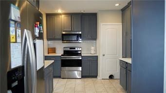 5007 Euclid Ave, Kansas City, MO 64130 - kitchen with stainless steel appliances, light countertops, light tile patterned floors, and recessed lighting