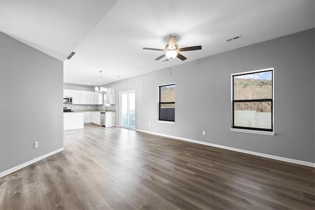 2814 N 100th St, Kansas City, KS 66109 - unfurnished living room with a chandelier, healthy amount of natural light, ceiling fan, and dark wood-style flooring