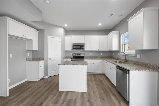 2814 N 100th St, Kansas City, KS 66109 - kitchen with stainless steel appliances, wood finished floors, white cabinetry, a center island, and recessed lighting