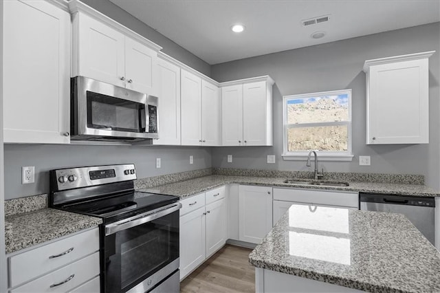 2814 N 100th St, Kansas City, KS 66109 - kitchen featuring appliances with stainless steel finishes, white cabinets, light stone counters, and recessed lighting