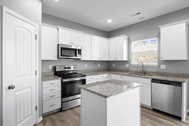 2814 N 100th St, Kansas City, KS 66109 - kitchen featuring stainless steel appliances, light wood-type flooring, white cabinets, light stone countertops, and recessed lighting