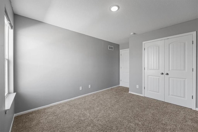 2814 N 100th St, Kansas City, KS 66109 - unfurnished bedroom with carpet, a closet, and a textured ceiling