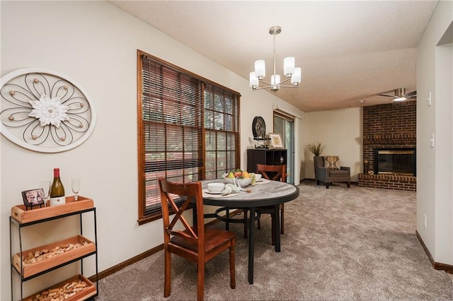 2618 Manor Ter, Lawrence, KS 66046 - dining space with carpet, a chandelier, a ceiling fan, and a fireplace