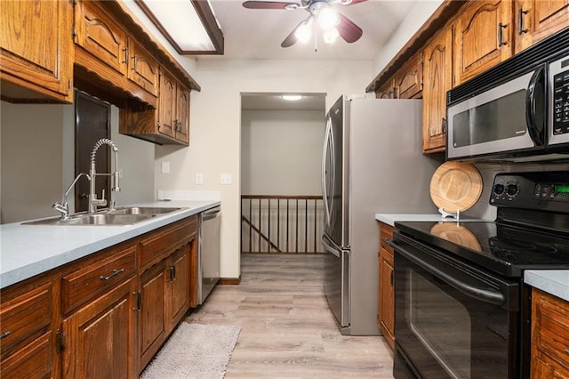 2618 Manor Ter, Lawrence, KS 66046 - kitchen with electric range, light wood finished floors, light countertops, ceiling fan, and stainless steel dishwasher