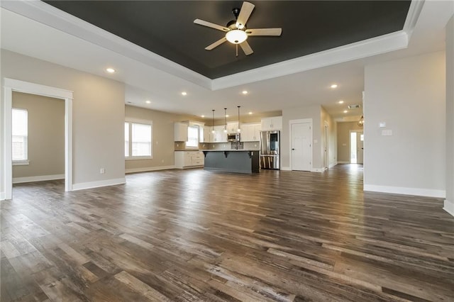 15904 E Cogan Ln, Independence, MO 64050 - unfurnished living room with a raised ceiling, crown molding, ceiling fan, dark wood-style floors, and recessed lighting